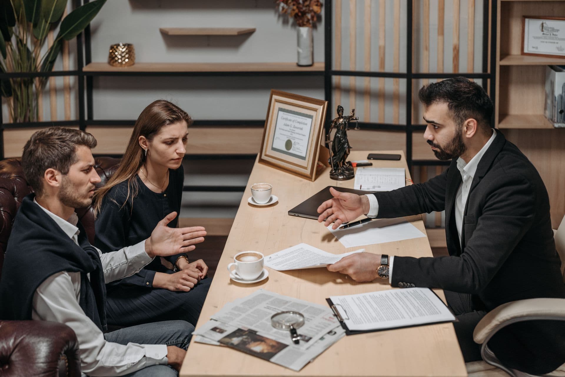 Attorney discussing legal documents and case details with a couple during a consultation in an office.