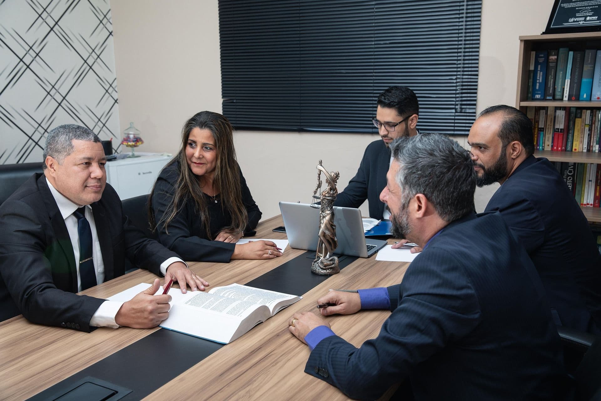Law firm team collaborating during a meeting in an office, illustrating legal practice management and teamwork.