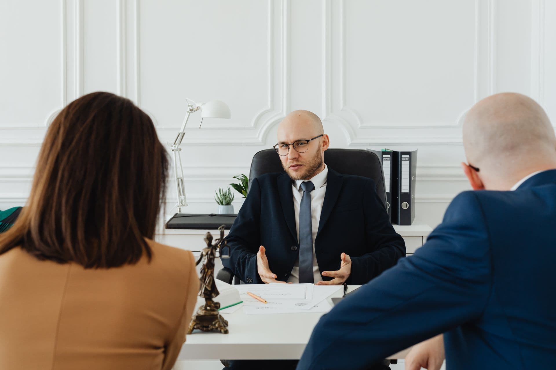 Lawyer consulting with clients in a modern professional law office.