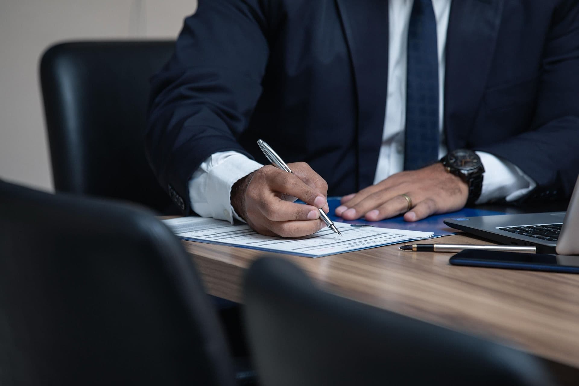 Lawyer signing paperwork at a desk, representing manual collections challenges in a law firm.