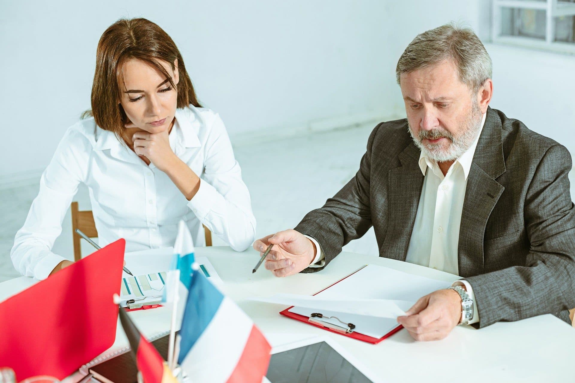 Lawyer and client reviewing documents and discussing contract details during a consultation meeting.